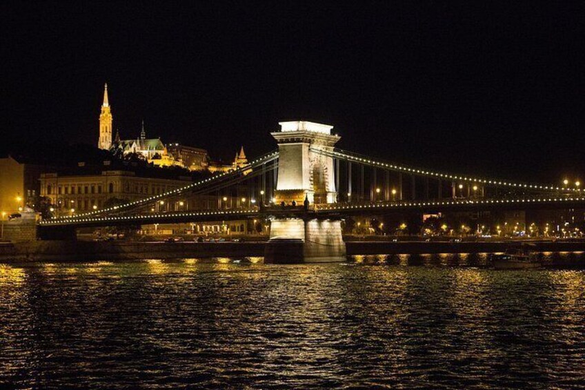 A lit bridge at night with a cityscape in the background. 4