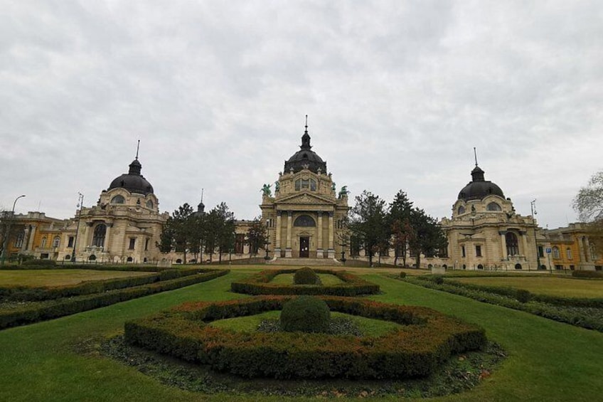 Un imposant bâtiment doté de trois dômes, entouré d’un jardin magnifiquement entretenu, agrémenté de haies aux formes géométriques. 1