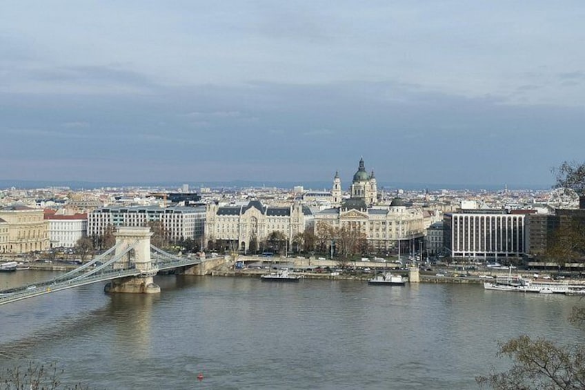 Une rivière traversée par un pont, un grand bâtiment surmonté d’un dôme, et une vue sur la ville en arrière-plan. 3