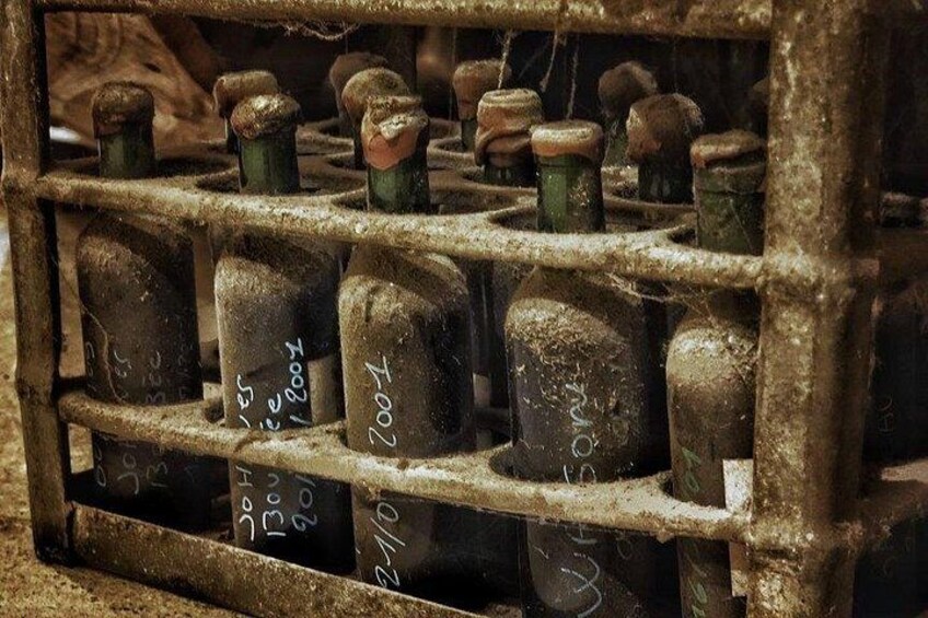 A metal rack with bottles labeled with dates and numbers. 2