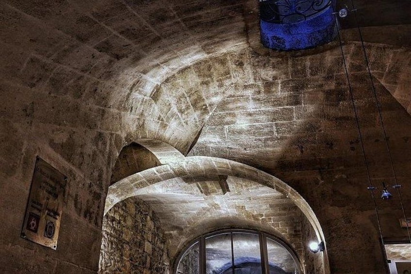 An arched stone ceiling with a stained glass window at the base. 5