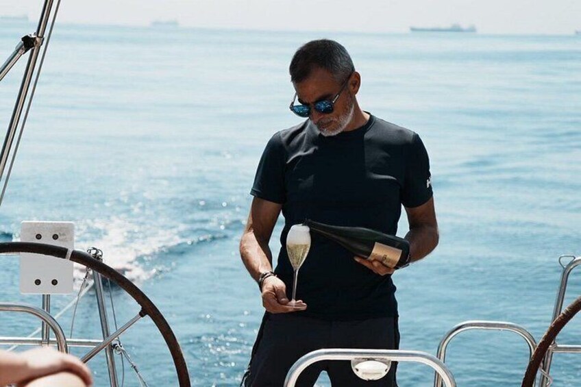 A person pouring champagne on a boat. 4