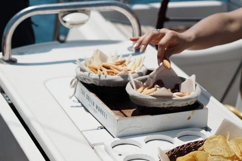 A boat with a tray containing food items and a person reaching for something. 2