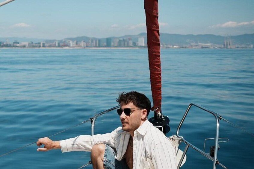 A person on a sailboat with a cityscape in the background. 5