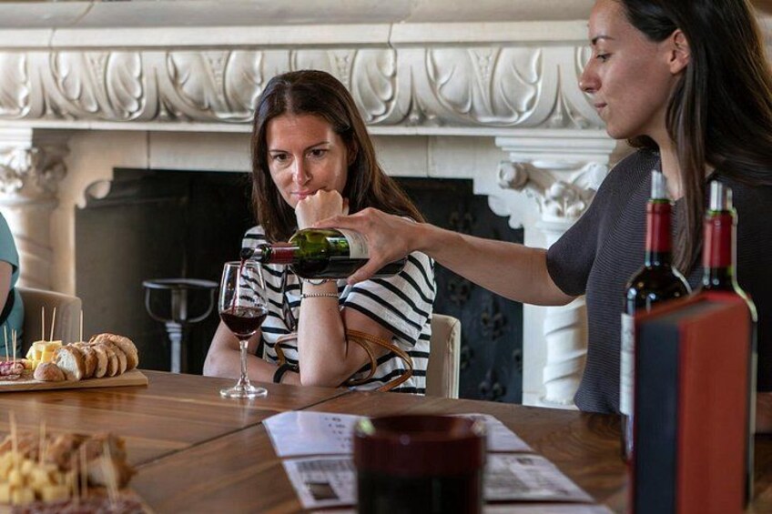 Two people at a dining table with wine glasses, a bottle of wine, and a menu. 1