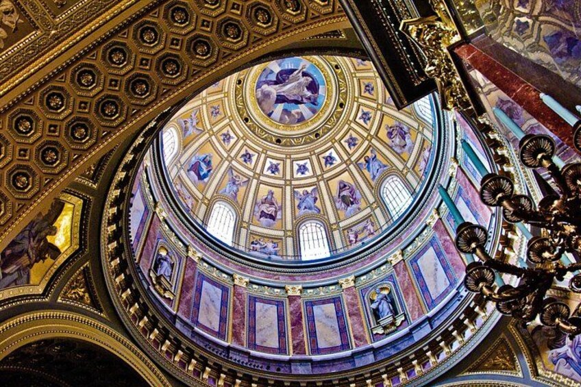 A grand, ornate ceiling with intricate designs and a central circular fresco. 5