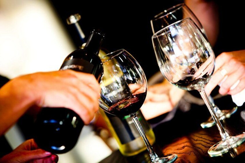 A person pouring wine into a glass. 3