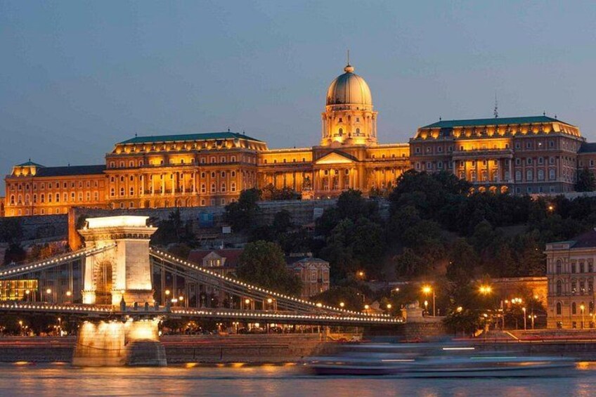 A grand building with a dome, a bridge with lights, and a river in the foreground. 5