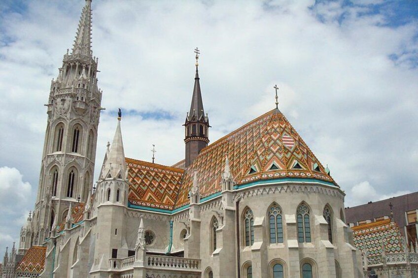 A historic cathedral with intricate architecture, including a tall spire and a patterned roof. 4