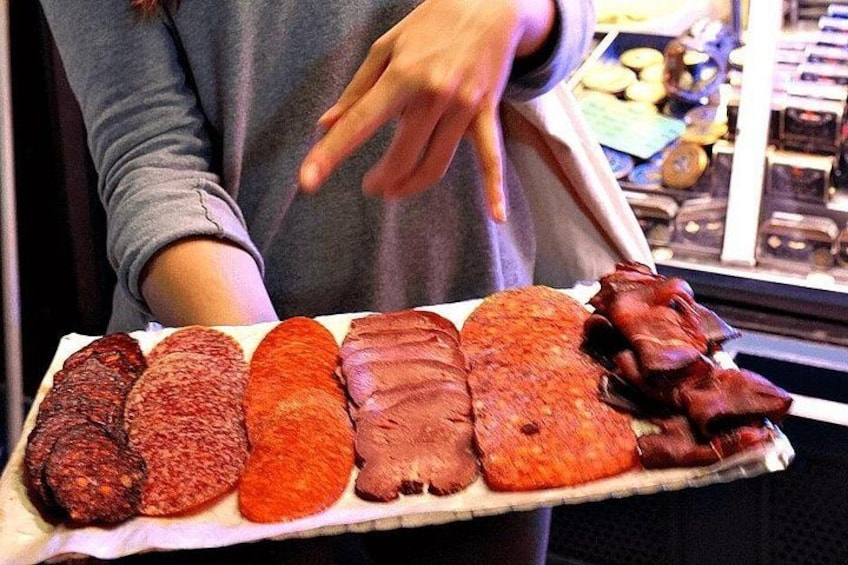 Una persona sostiene una bandeja con varios tipos de embutidos. 2