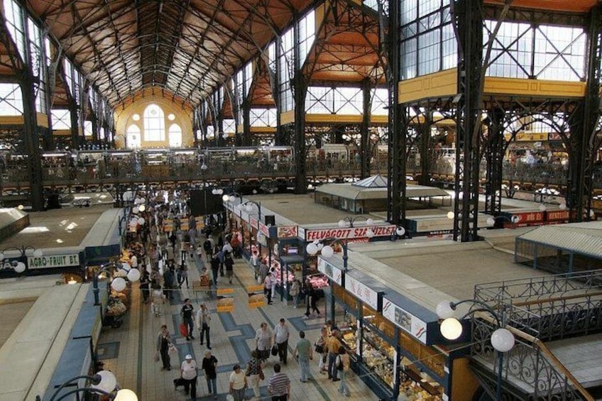 Un mercado interior con varios puestos y un techo alto. 1