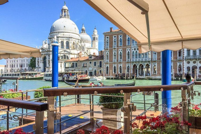 A canal with gondolas, a large domed building, and a bridge. 2