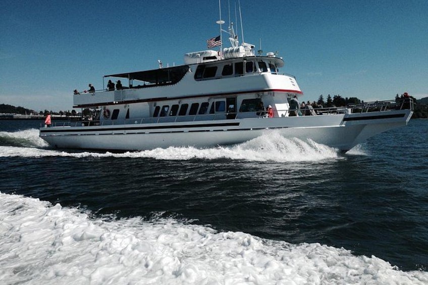 A white boat with a red stripe on the side, moving through the water. 2