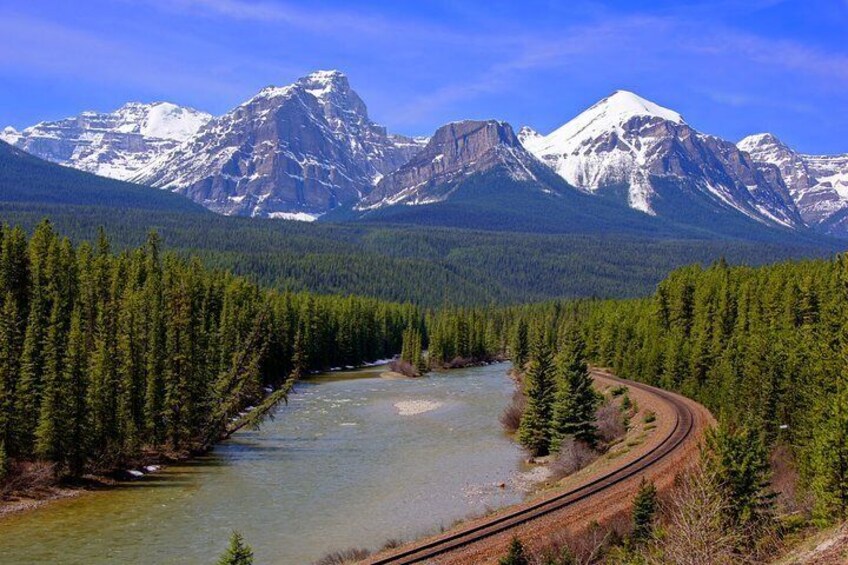 A river, a railway track, and snow-capped mountains. 5