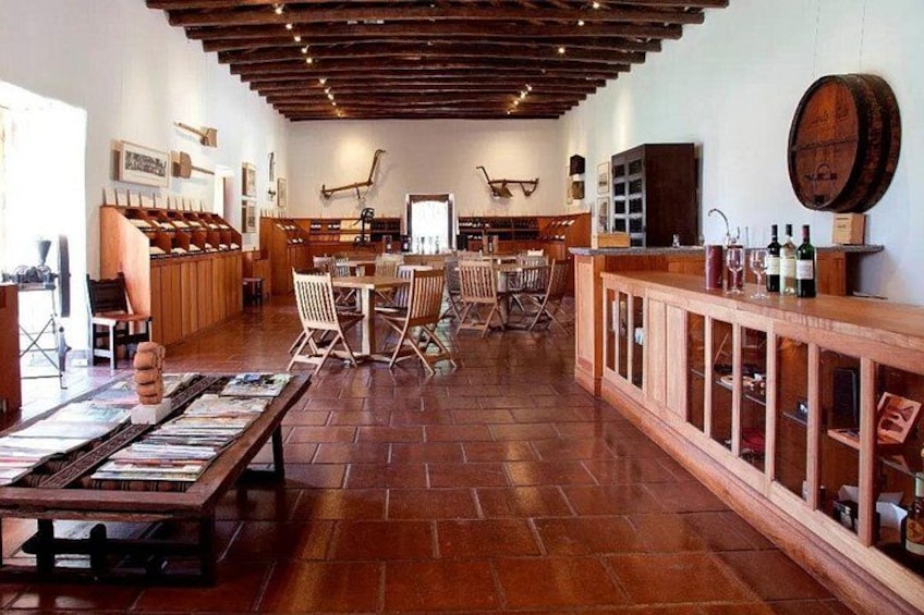 A rustic interior with wooden floors, a long bar, and wine racks. 5