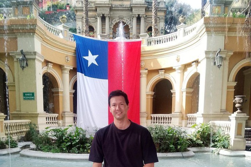 Un homme se tient devant une fontaine, un grand drapeau à la main. 1