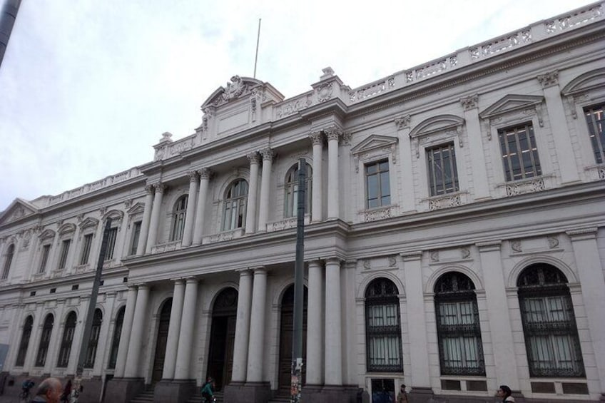A classical building with columns, large arched windows, and decorative elements. 4