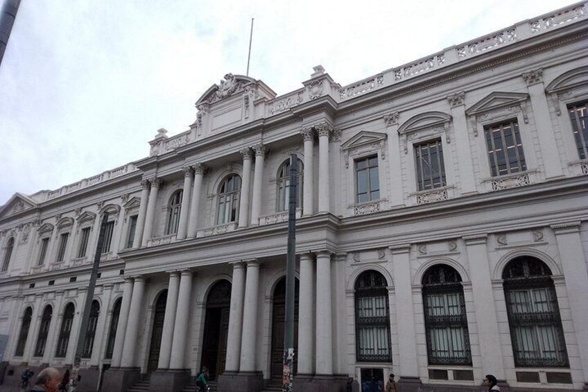 A large classical building with columns, arched windows, and decorative elements. 2