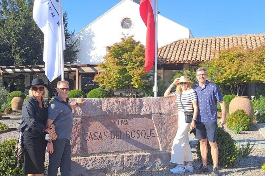 A group of people standing in front of a building with a sign that reads 'CASAS DEL ROSQUE'. 3