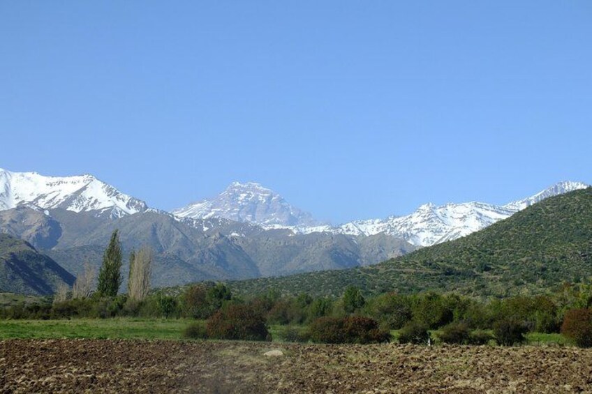 A mountainous landscape with snow-capped peaks, a river, and green vegetation. 5