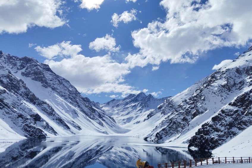 A snow-covered mountain landscape with a clear sky and a frozen lake reflecting the mountains. 1