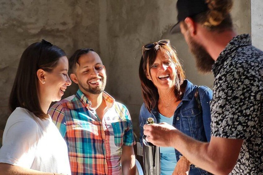 A group of people standing outdoors, engaged in conversation. 3