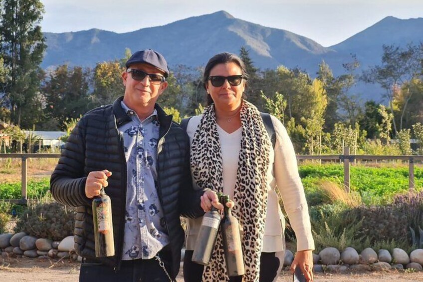 Two people standing outdoors with a mountainous landscape in the background. 2