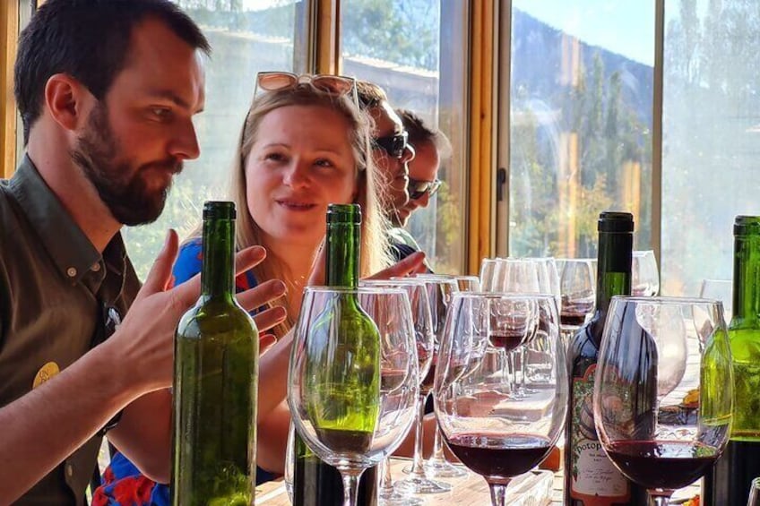 People at a table with wine bottles and glasses. 5