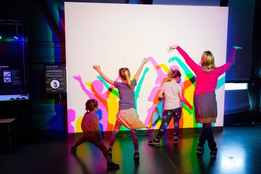 A group of people dancing in front of a colorful backdrop. 5
