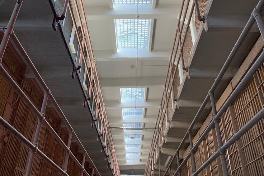 A multi-level indoor structure with metal railings and wooden slats, featuring skylights and a high ceiling. 4