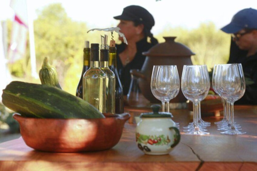 A table with a copper bowl, bottles, glasses, and a teapot. 5