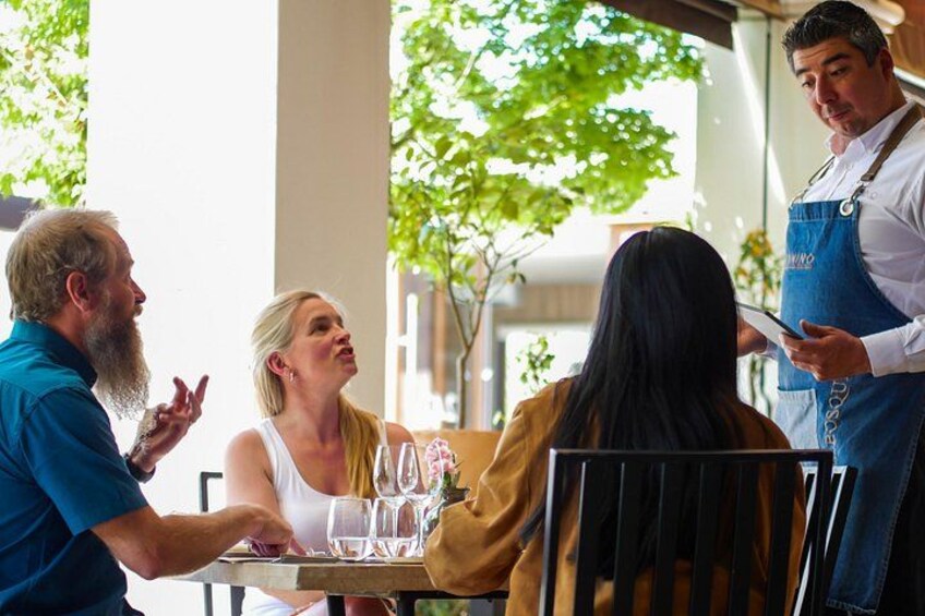 A restaurant setting with a waiter serving a table. 5
