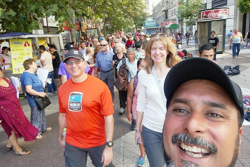 A crowded street with people walking, a Coca-Cola sign, and a McDonald's sign. 1