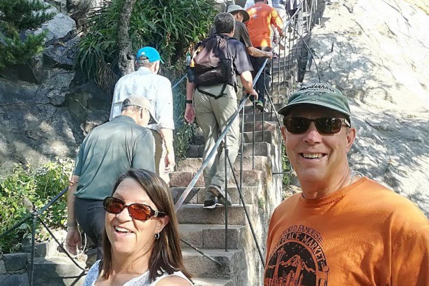 A group of people ascending a stone staircase outdoors. 5