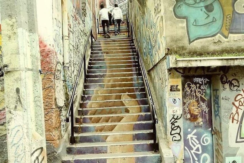 A staircase with graffiti, leading up to a building entrance. 2