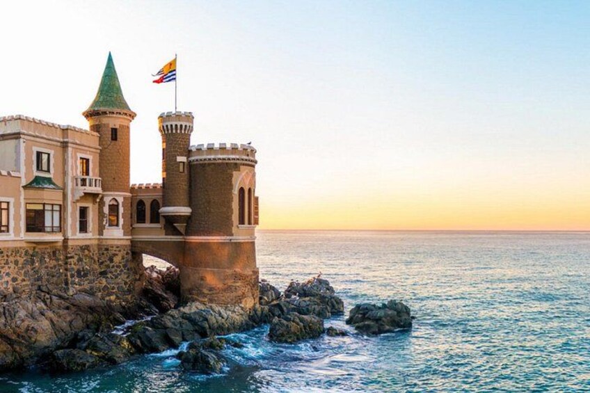 Un château situé sur la côte, doté d’une tour, d’un drapeau et bordé d’une falaise rocheuse. 5