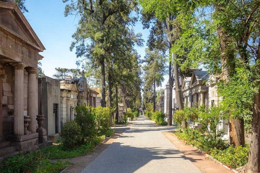 A tree-lined street with classical architecture. 1