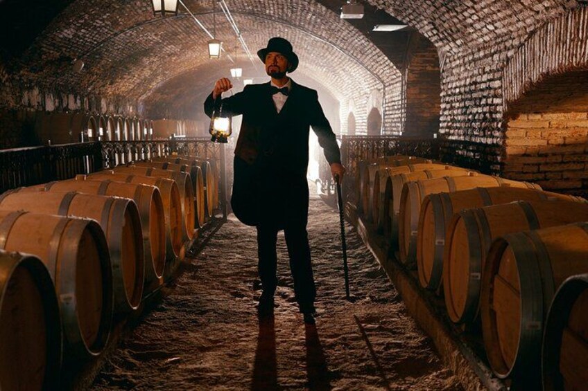 A person in a dimly lit cellar with wooden barrels. 1