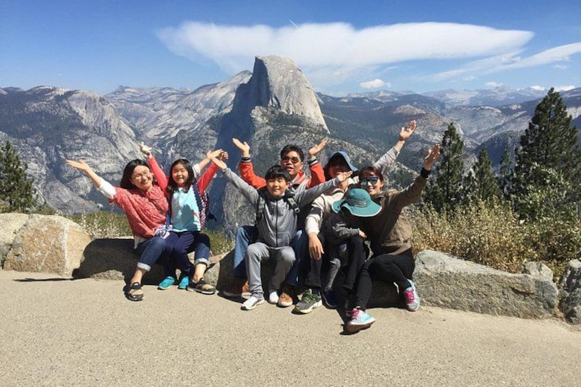 A group of people posing on a road with a mountain range in the background. 4
