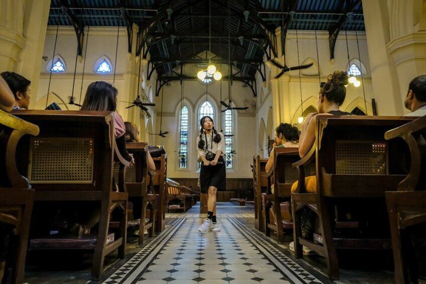 A church interior with wooden pews, a central aisle, and stained glass windows. 1