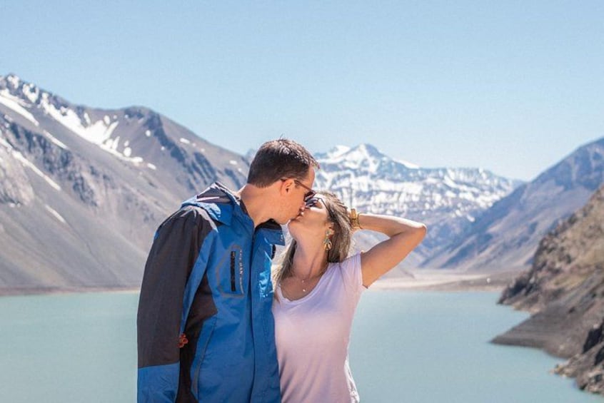 Una pareja de pie junto a un lago con montañas al fondo. 2