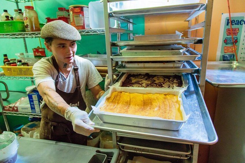 Een persoon in een keuken, die een dienblad met eten vasthoudt. 3