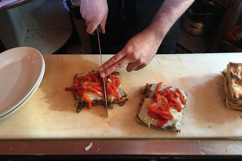 Iemand snijdt een sandwich op een snijplank. 2