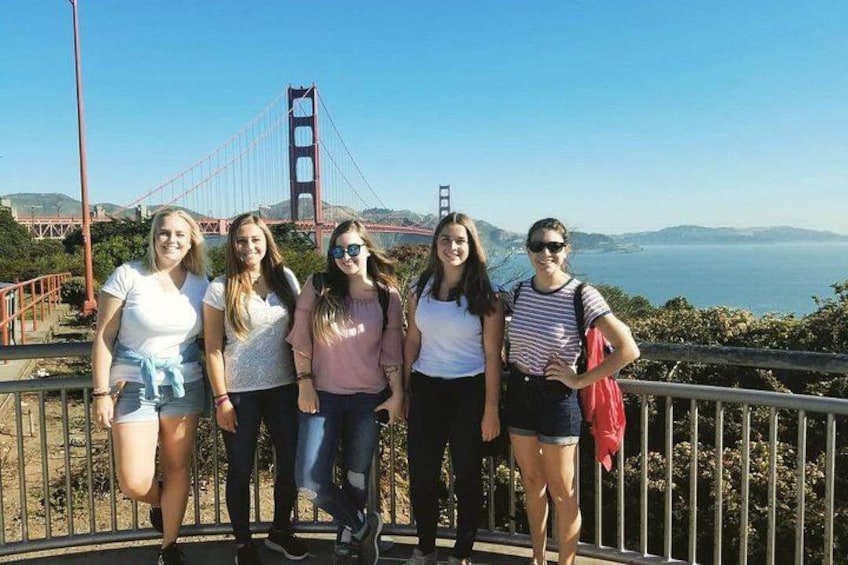 En grupp människor som står på en bro med Golden Gate-bron i bakgrunden. 4