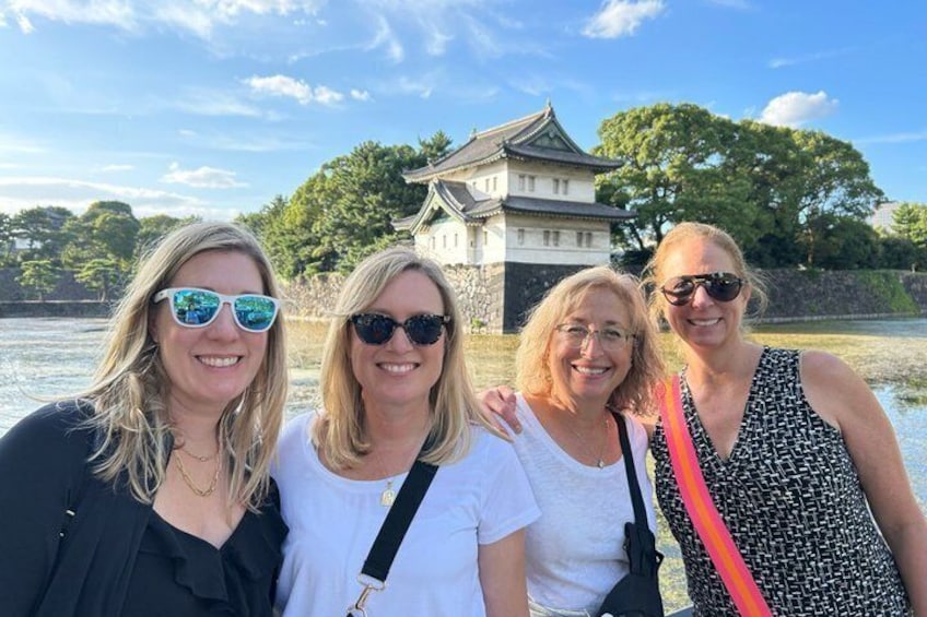Drei Personen stehen vor einem traditionellen japanischen Gebäude an einem Gewässer. 1