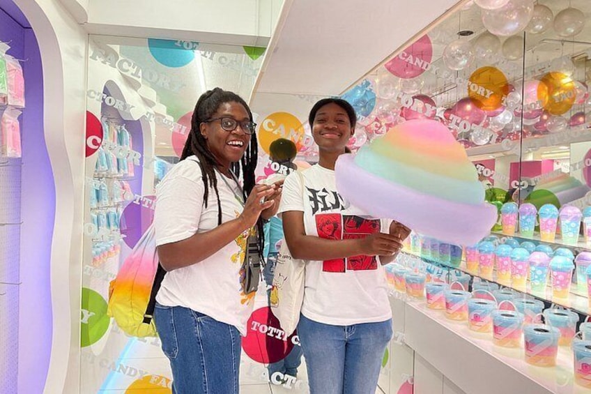 Dos personas en una tienda con decoraciones coloridas y estantes llenos de productos. 2