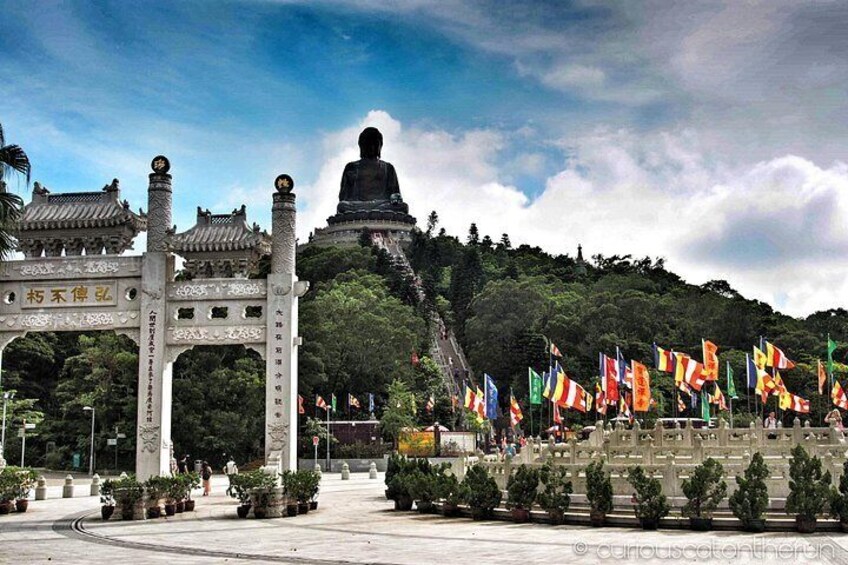 Una gran estatua de Buda, arquitectura china tradicional y numerosas banderas. 1