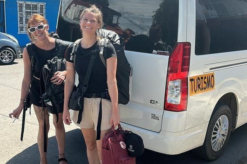 Two people walking beside a white van with 'TURISMO' written on it. 3