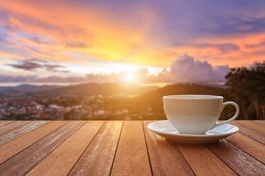 Eine weiße Tasse auf einem Holztisch mit Blick auf einen malerischen Sonnenuntergang. 5