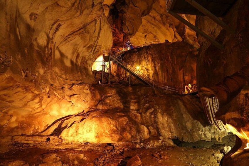 A cave with a wooden staircase leading to a higher level. 1